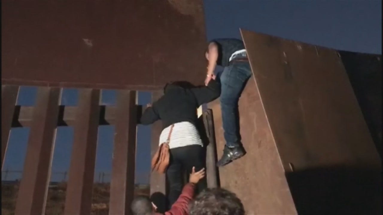 Migrants Jump Over Border Fence In Tijuana